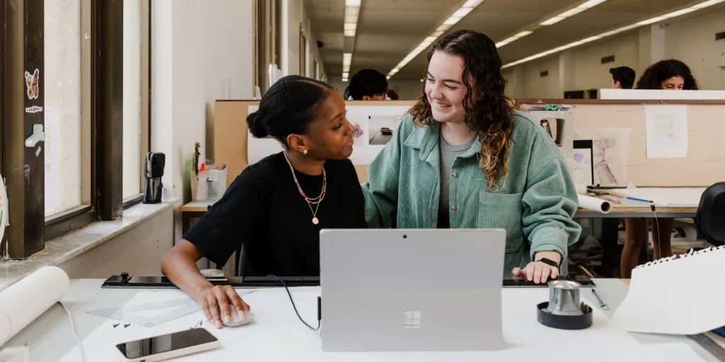 Students smiling at each other while working on a project together