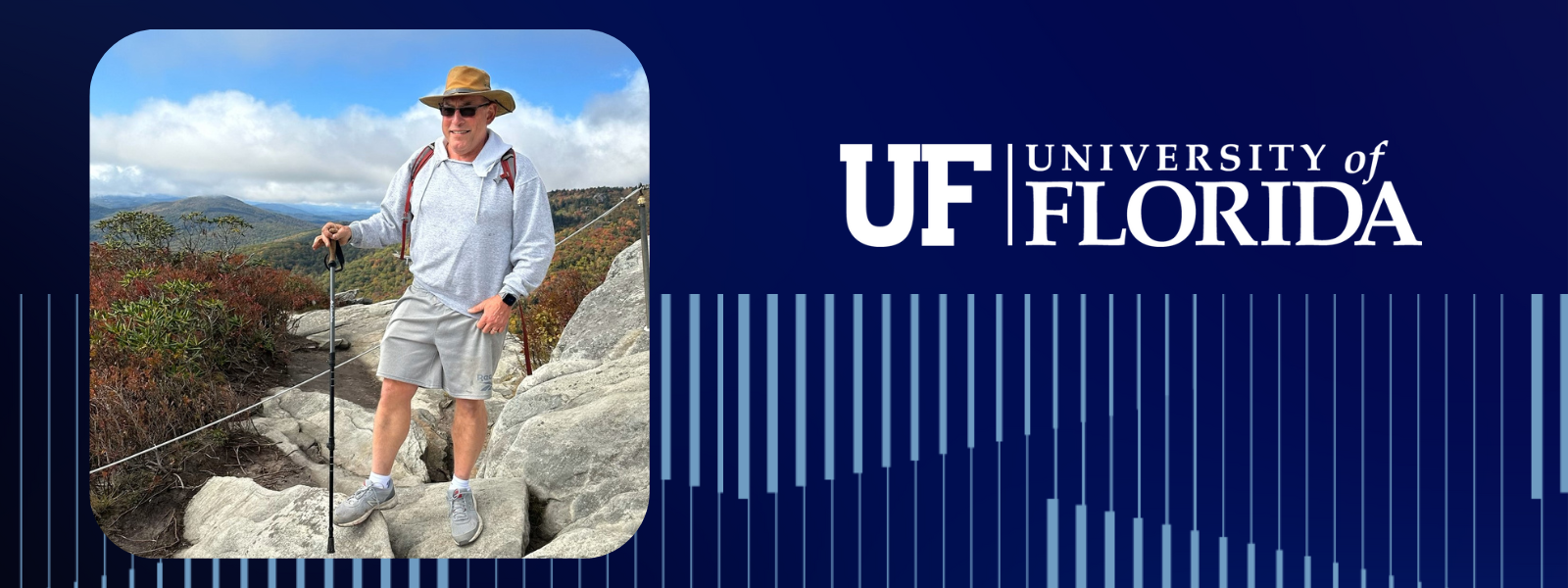 John Sullivan stands on rock with scenic landscape.
